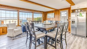 A modern kitchen with a large island, wooden cabinetry, and a stainless steel refrigerator. - Ocean view home 1 block from the beach with hot tub deck and fireplace (Lincoln City)