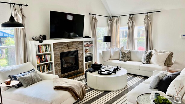 A modern living room with a fireplace, white sofas, a coffee table, and a flat-screen TV. - Cottage de la Mer House in Lincoln City with serene porch walk to the beach (Lincoln City)