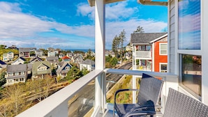 Un balcón con vista a una zona residencial, que incluye casas y una calle.