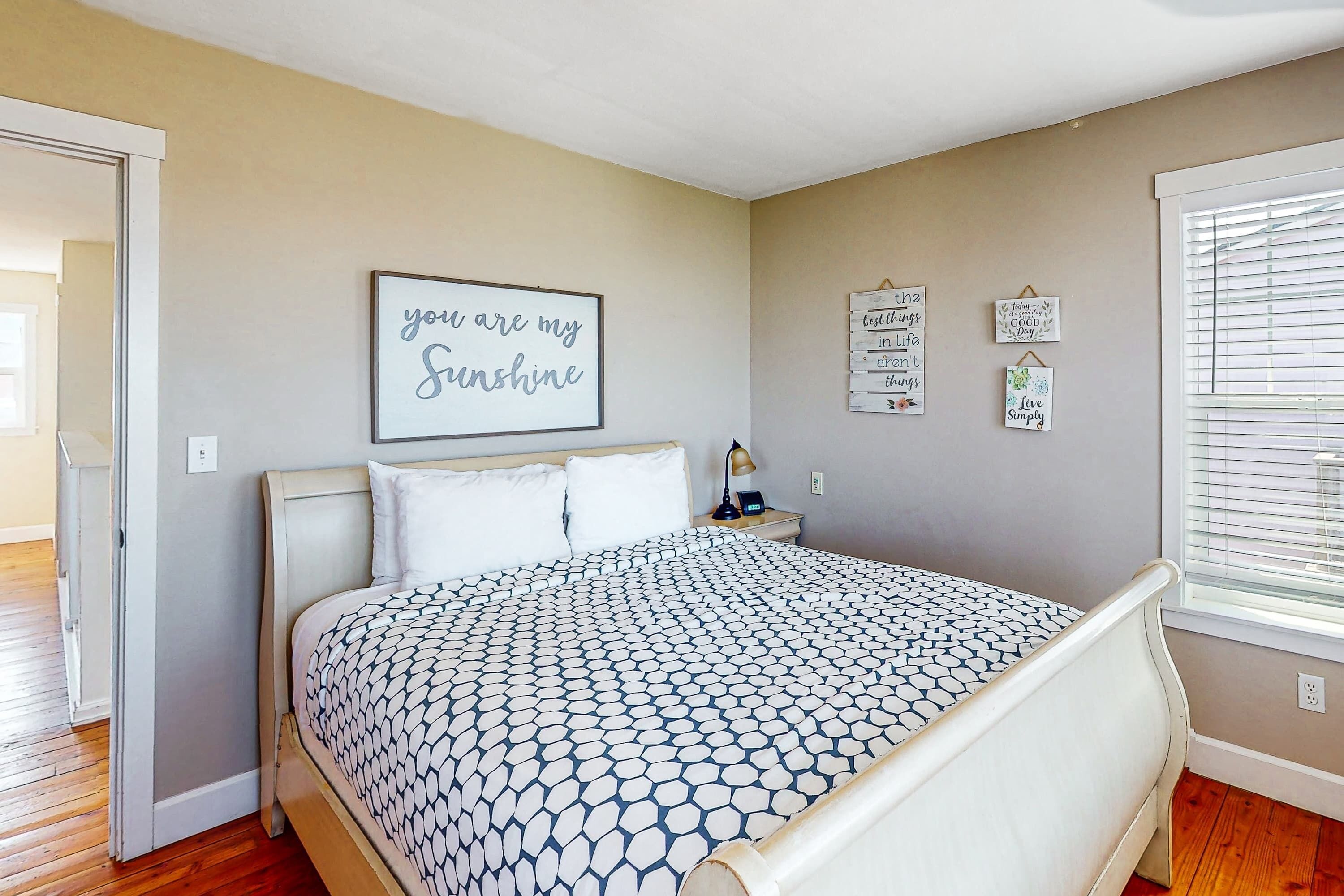 Ein Schlafzimmer mit Bett, Nachttisch und Wanddekorationen.