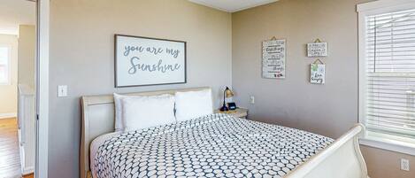 Une chambre à coucher comprenant un lit, une table de chevet, une commode et des éléments de décoration murale.