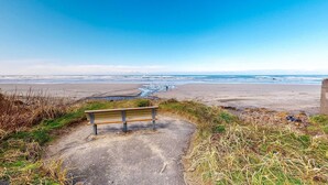 Un banc placé face à une plage, offrant une vue dégagée sur l’océan.
