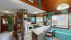 Une cuisine avec des meubles de rangement en bois, un four à micro-ondes, une cuisinière et un évier.