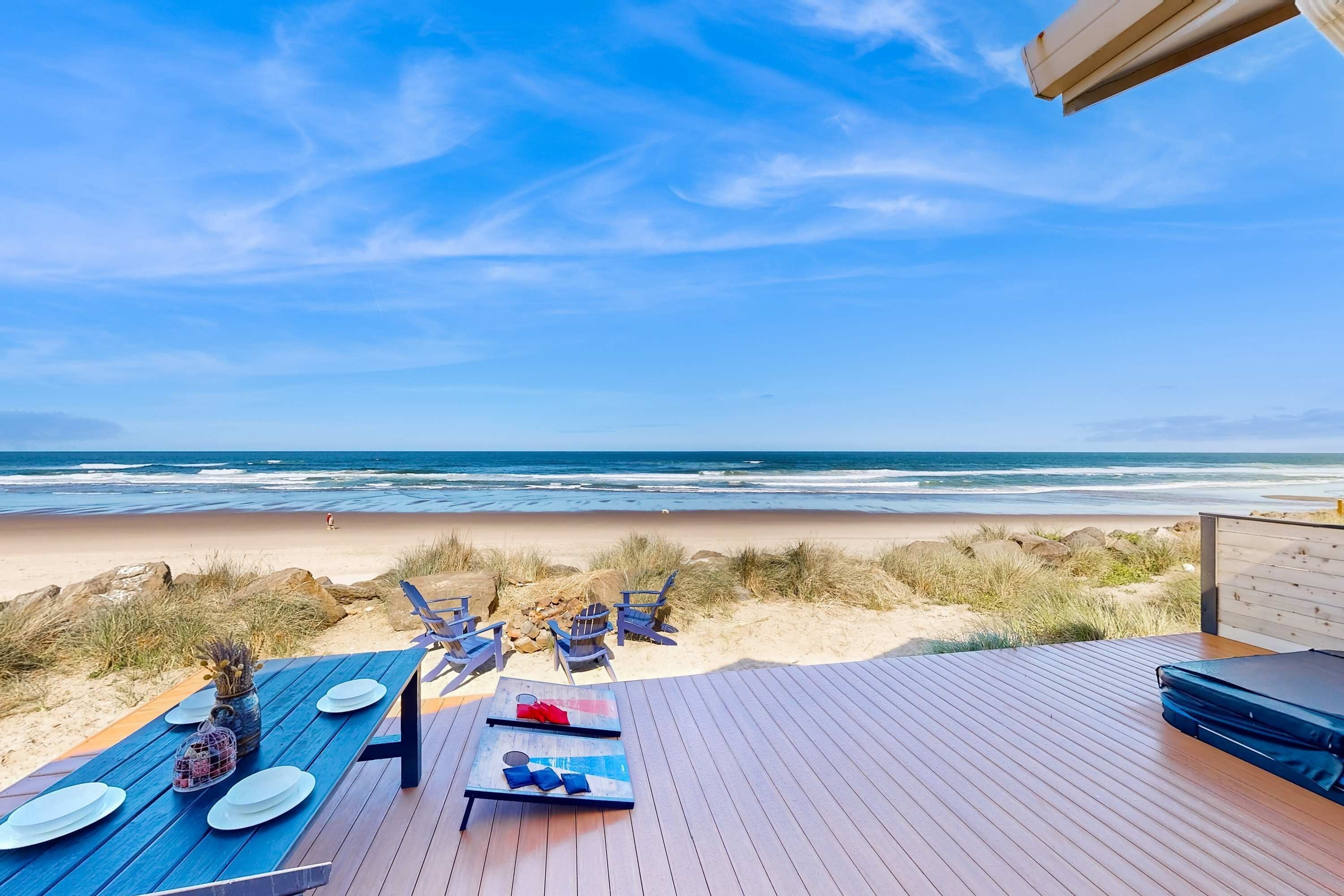A wooden deck with a view of the beach and ocean.