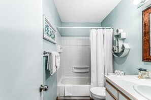 A bathroom with a bathtub, toilet, and sink. - Oceanfront 2nd floor condo with river ocean views balcony (Neskowin)