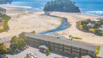 A coastal hotel with a parking lot, beach access, and ocean views.