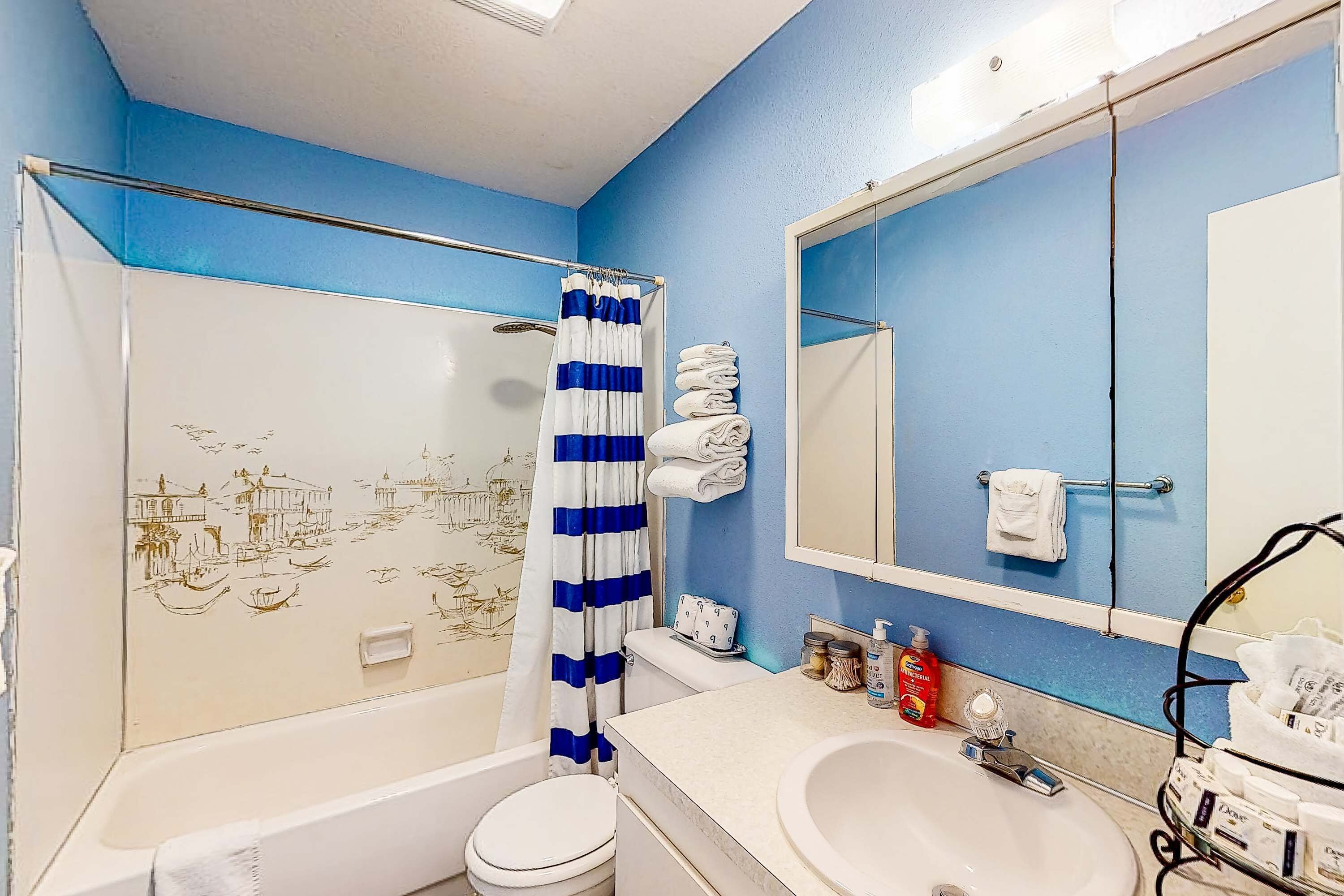 Een badkamer met een bad, toilet, wastafel en douchegordijn.