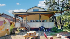A house with a covered patio, a barbecue area, and a picnic table. - Newly constructed home with firepit and large deck walk to the beach and golf (Neskowin)