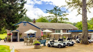 Ein Gebäude mit Veranda, Außenbereich mit Sitzgelegenheiten und Golfcarts.