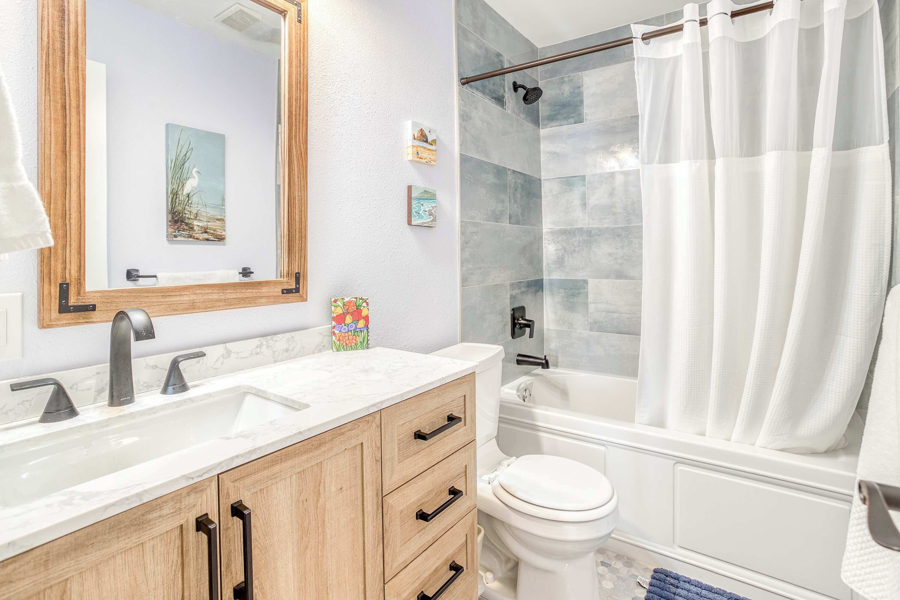 Une salle de bain avec douche, toilettes et lavabo.