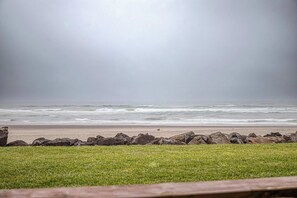A beach with a grassy foreground and a rocky shoreline. - Renovated Oceanfront Condo w/Beach Access & Views | Pet-Friendly (Neskowin)