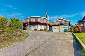 Une maison à deux étages avec un balcon, un garage et une allée.