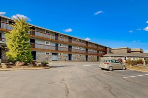 A multi-story hotel with a parking lot and a car parked in front. - Beachfront dog friendly studio with amazing Proposal Rock view steps to the sand (Neskowin)