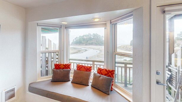 A bay window with three wicker baskets and orange cushions. - Oceanfront 2nd floor condo with ocean views balcony and seasonal beach access (Neskowin)