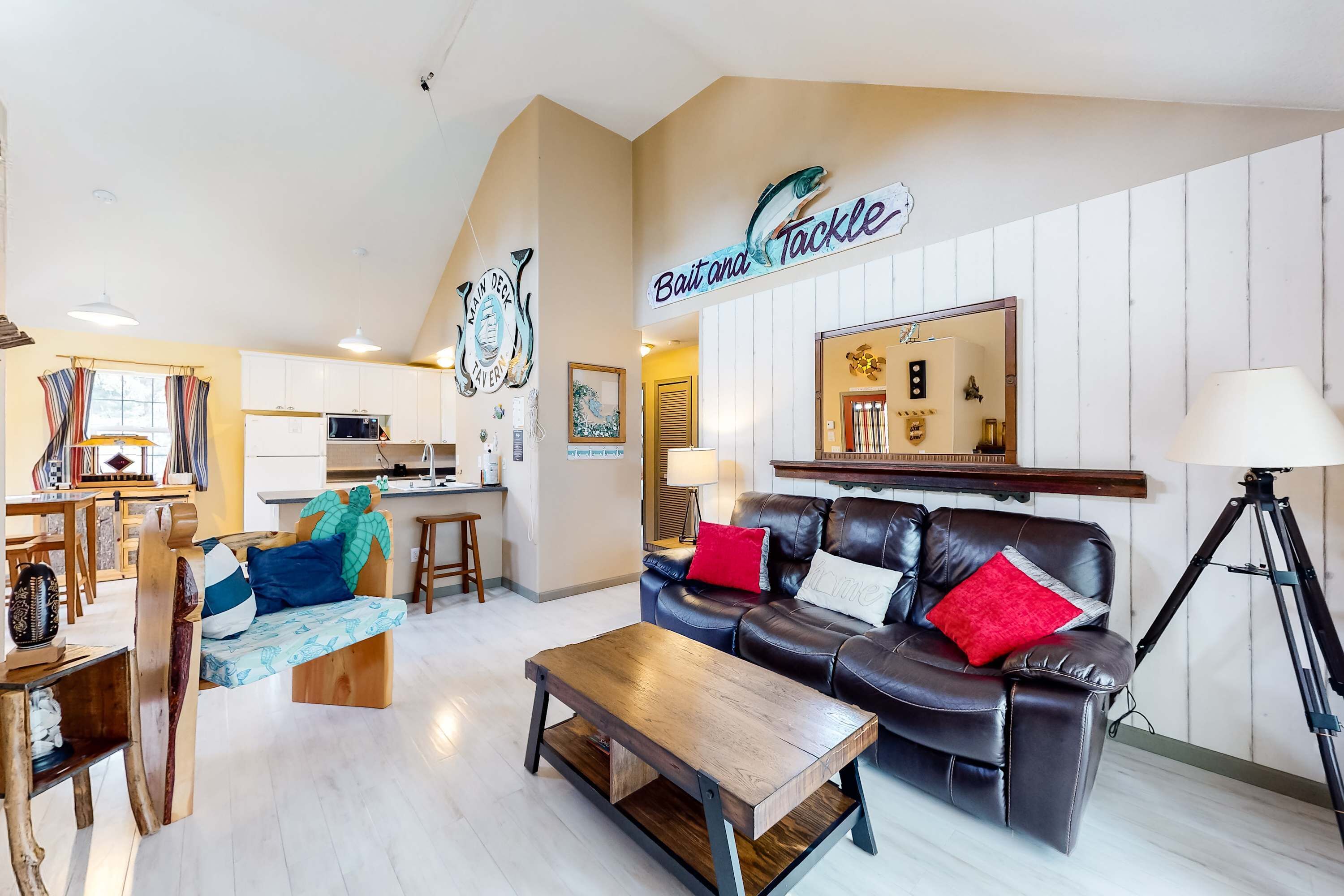 A living room with a sofa, a coffee table, and a dining area with a table and chairs.