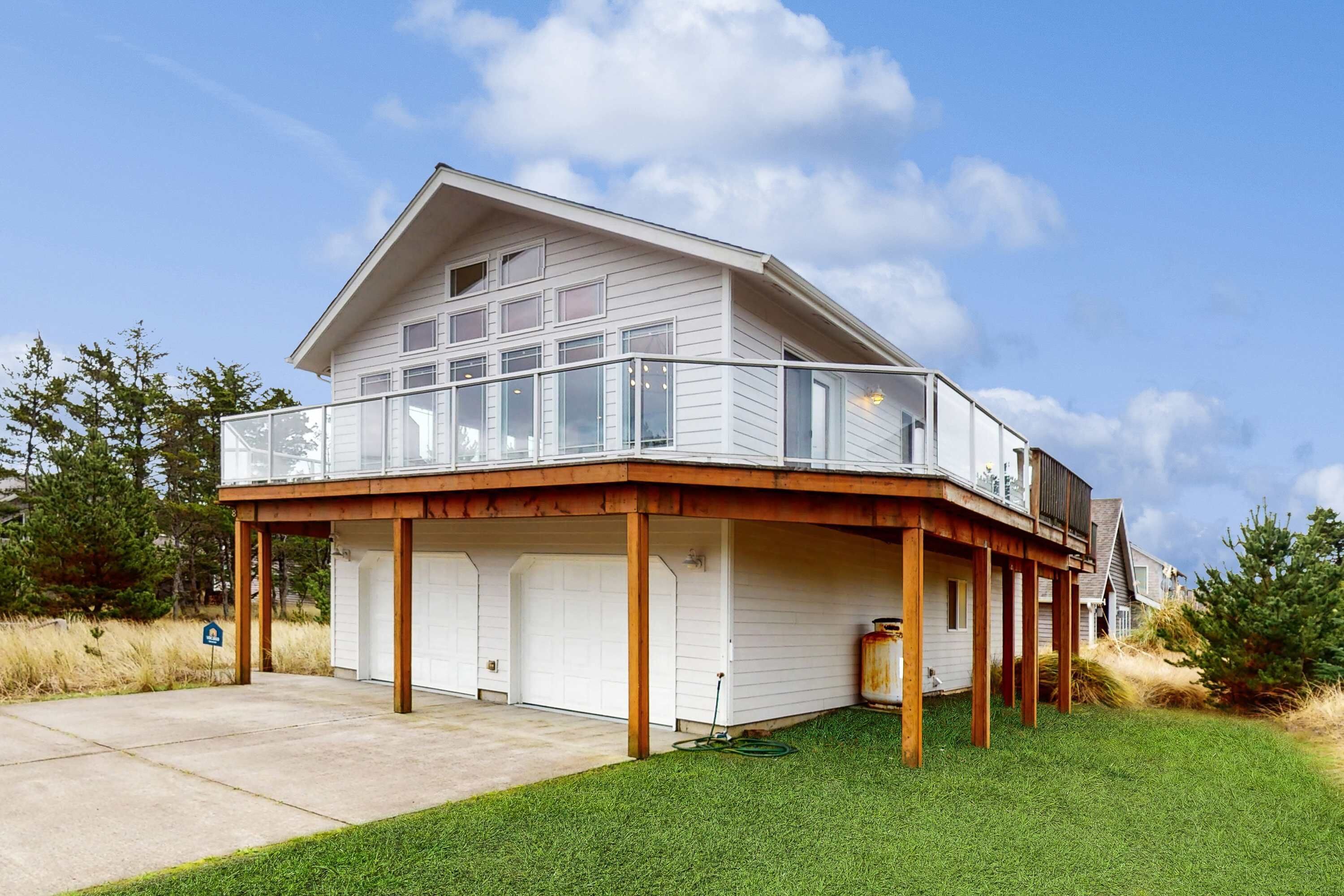 Ein zweistöckiges Haus mit überdachter Terrasse und Garage.
