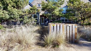 Une maison à deux étages, avec une façade en bois et une porte bien visible.