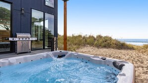 Un bain à remous sur une terrasse avec vue sur la plage et l’océan.