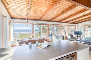A spacious kitchen with large windows, a dining area, and a view of the ocean. - Oceanfront cottage with hot tub beach access fireplace and WiFi Dog friendly (Cape Meares)