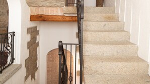 A staircase with stone steps and a wooden handrail, leading to a higher floor. - Casa al Duomo by Wonderful Italy (Telti)