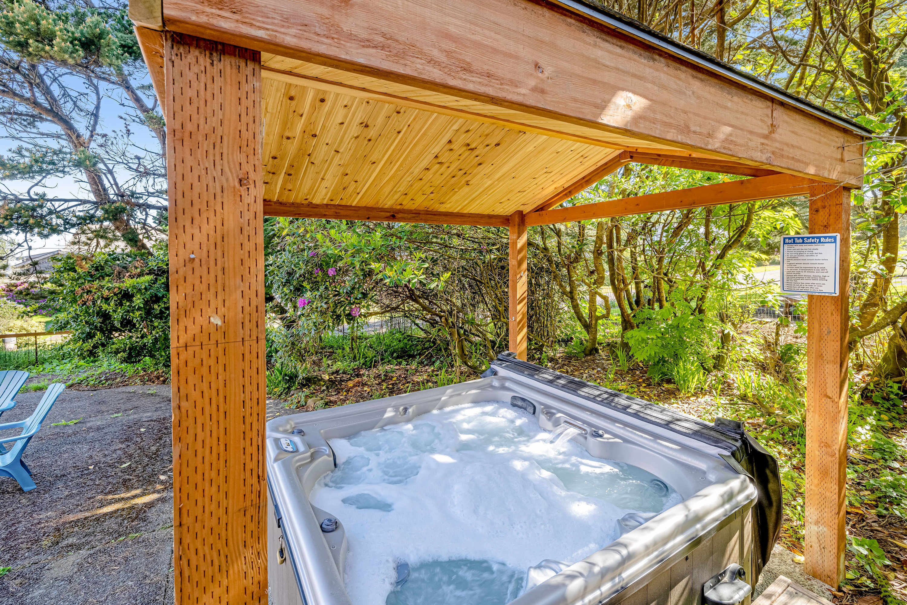 Un bain à remous sous une pergola en bois, dans un cadre verdoyant.