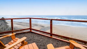 Terraza de madera con asientos que da a una playa.