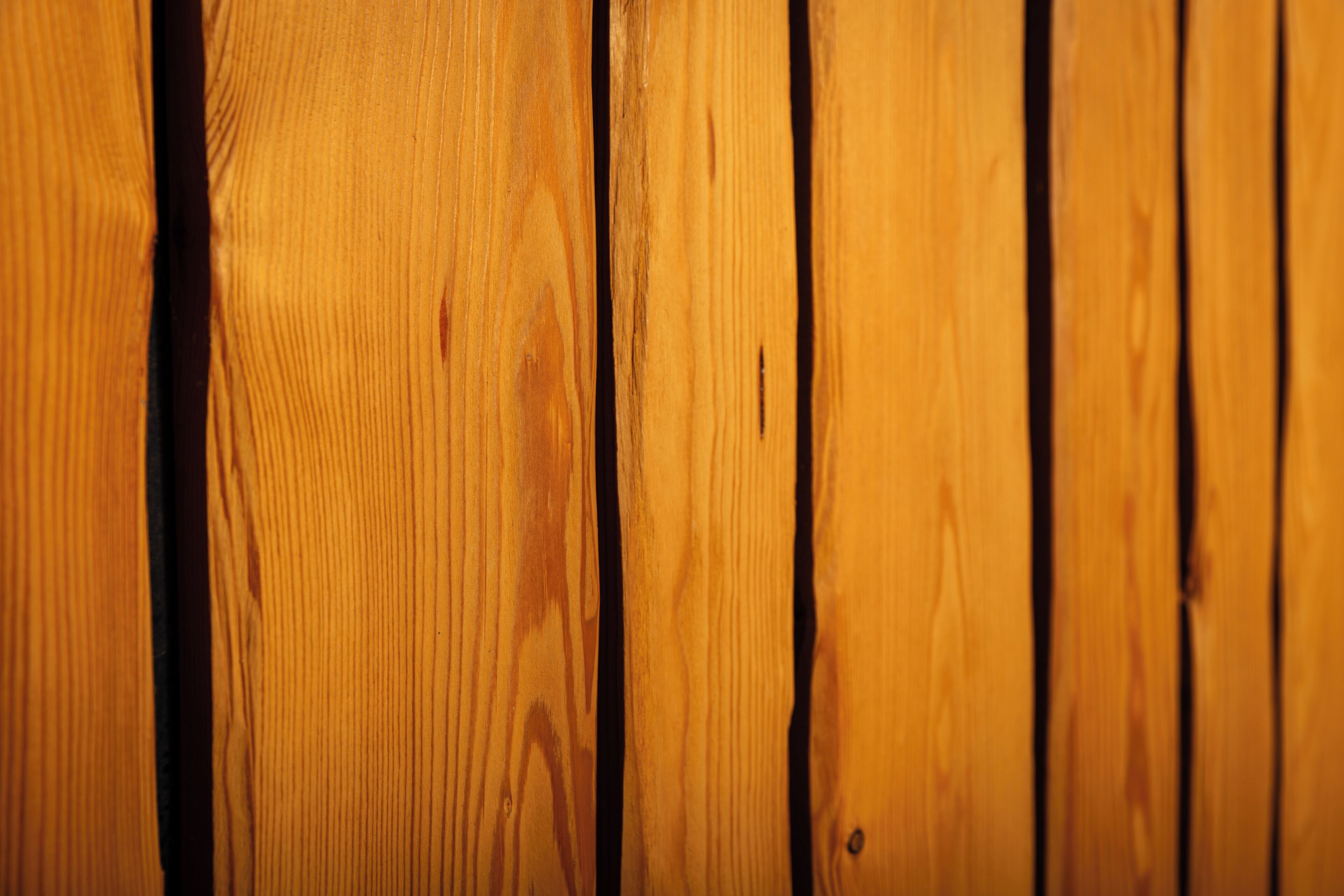 Primer plano de tablas de madera con vetas y nudos bien visibles.