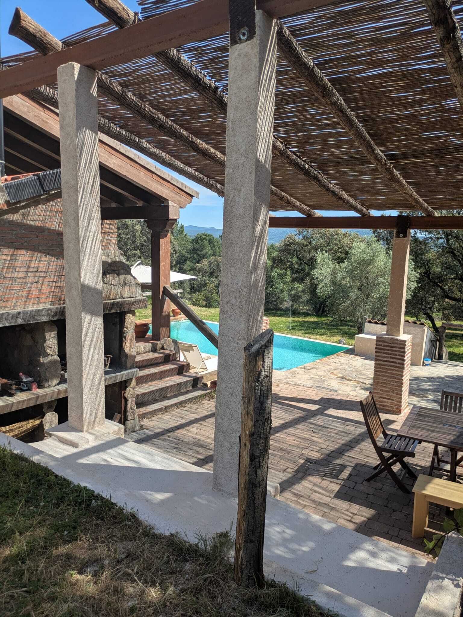 Un espacio al aire libre cubierto con piscina, escalones de piedra y mobiliario exterior.