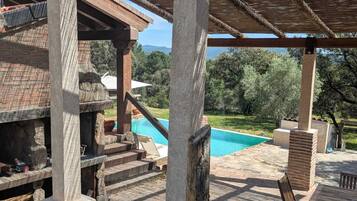 Un espacio al aire libre cubierto con piscina, escalones de piedra y mobiliario exterior.