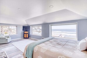 A bedroom with a large bed, a TV, a fireplace, and a view of the ocean. - Incredible Ocean Views Free WiFi Great Location (Oceanside)