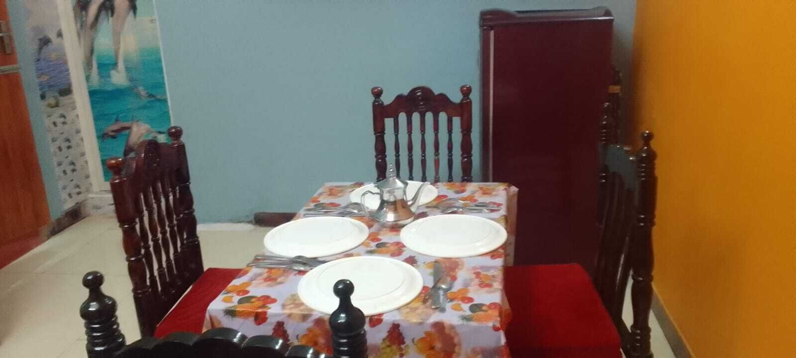 A dining table set with plates, cutlery, and a salt shaker.