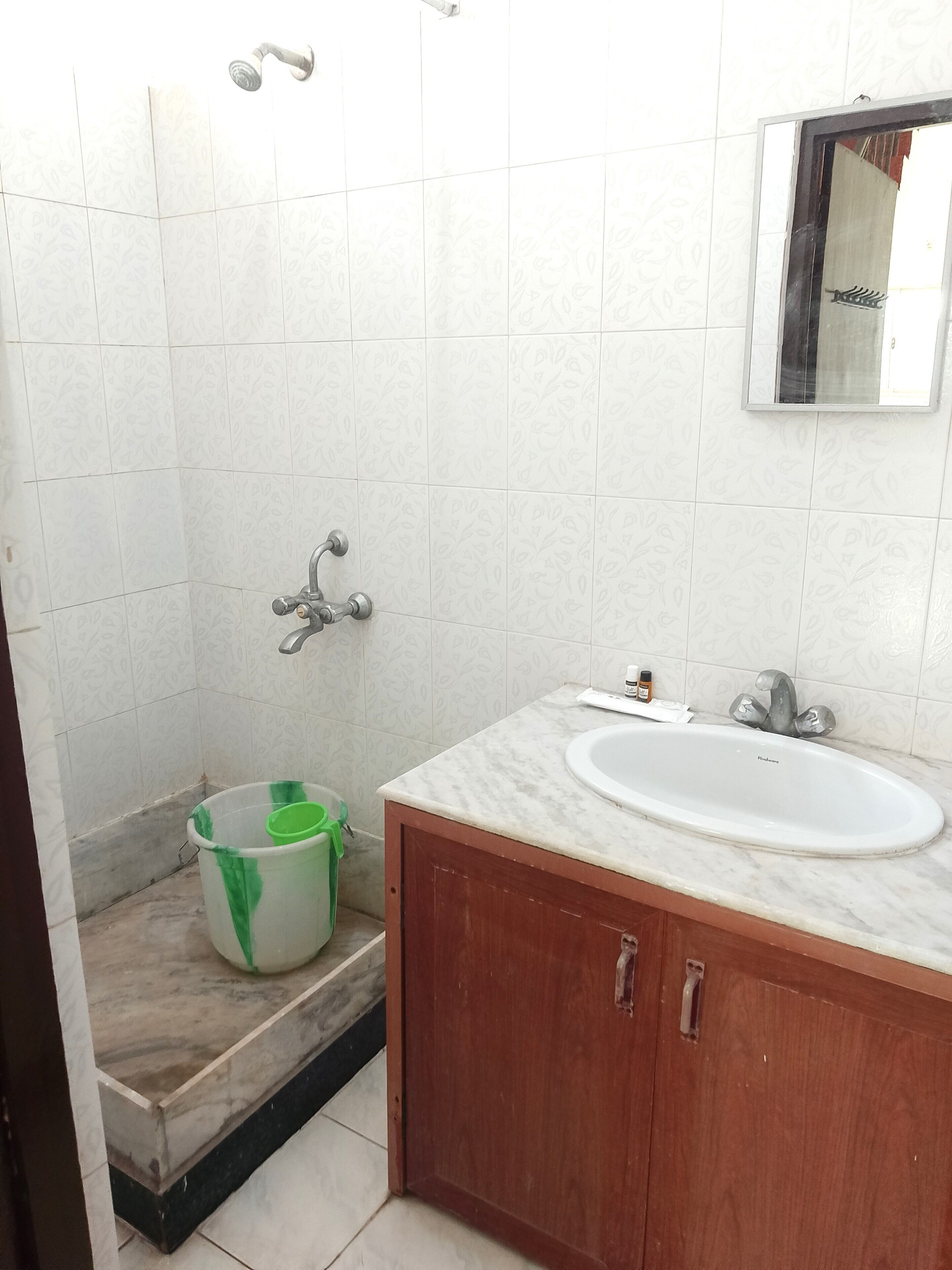 A bathroom with a shower, a sink, and a mirror.