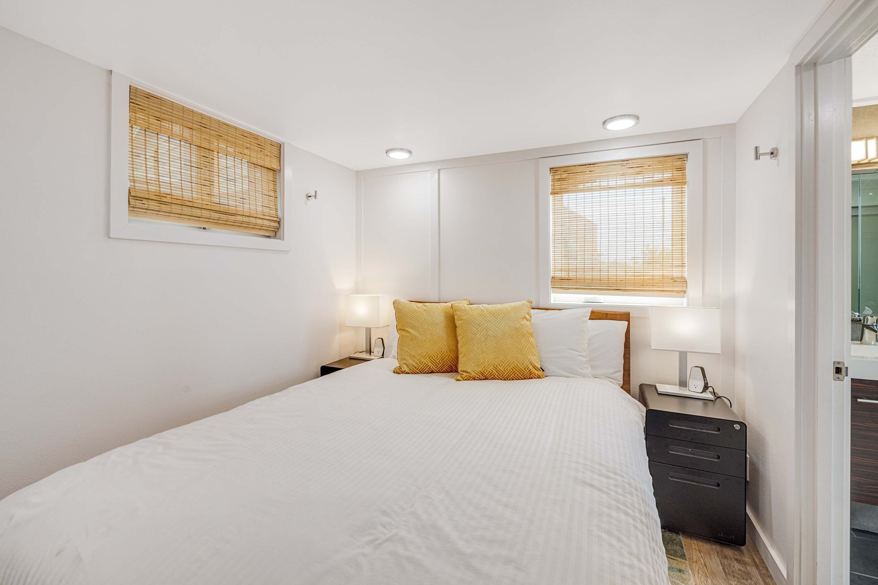 Une chambre à coucher avec un grand lit, deux lampes de chevet, une table de chevet et une commode.