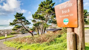 Segnaletica per il sito ricreativo di Oceanside Beach, con vista sull'oceano e sugli alberi.