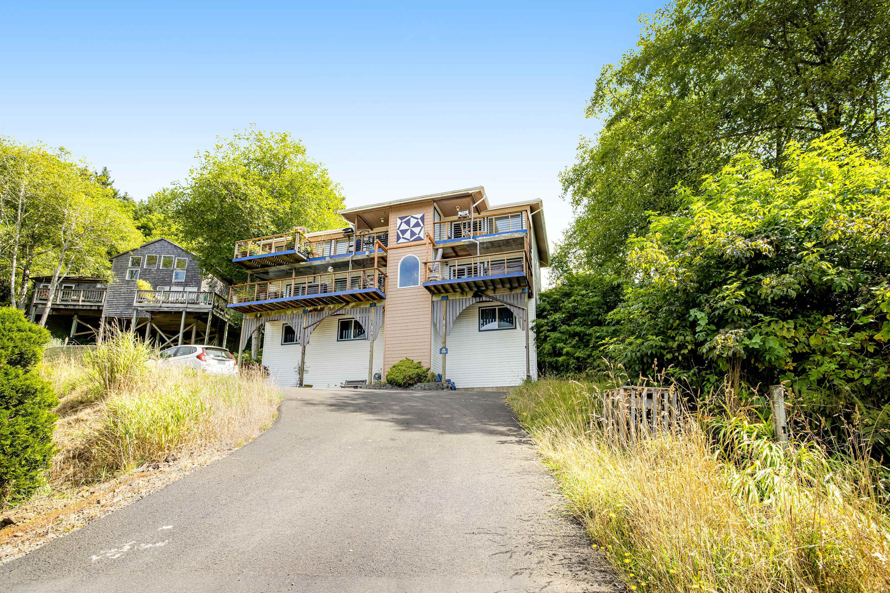 Ein mehrstöckiges Gebäude mit einem zentralen Innenhof, umgeben von Bäumen und einem Kiesweg.