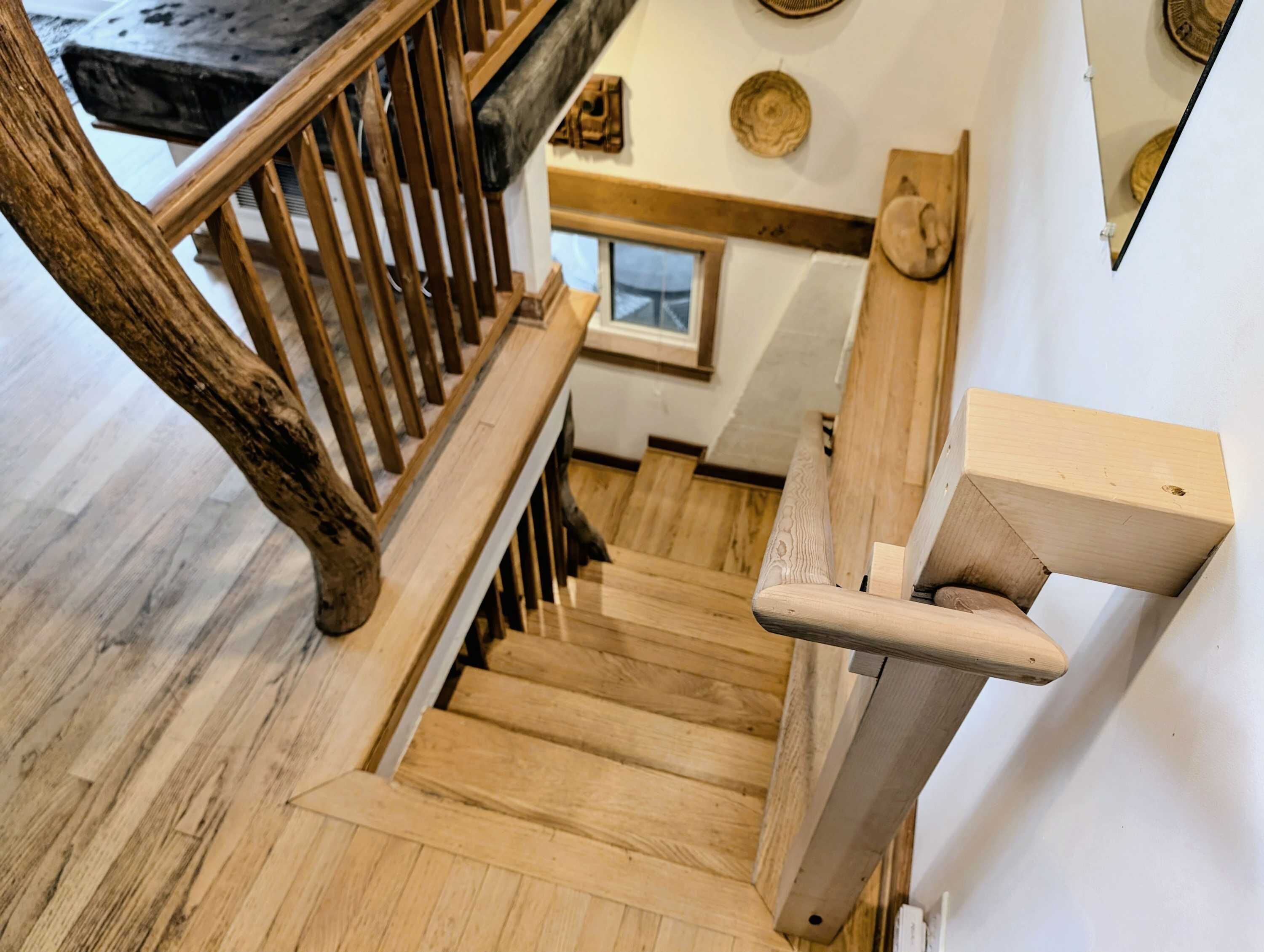 A wooden staircase with a handrail and a wooden handrail on the right side.
