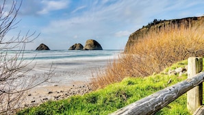 A beach with rocky outcrops and a wooden fence. - Dog Friendly house with ocean view private hot tub wall of windows (Oceanside)