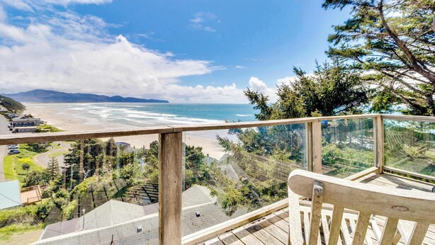 A wooden deck with a glass railing overlooking a beach and ocean. - Hand Built Gem with Two Large Decks and Incredible Views 1 4 Mile to the Beach (Oceanside)