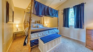 A four-poster bed with a canopy, a bedside table with a lamp, a bench at the foot of the bed, and a dresser. - Large Sunny Duplex with Ocean Views and Nearby Beach Access Dogs OK (Rockaway Beach)