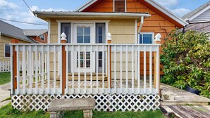 Een tweelaags huis met een witte picket fence, een stenen bankje en een klein voortuintje.