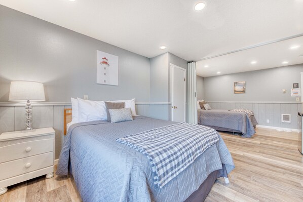 Une chambre à coucher avec un lit, une table de chevet et une lampe.
