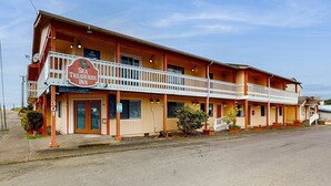 Un edificio di due piani con un cartello che indica 'Sea Treasures Inn' e un balcone.