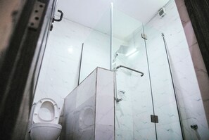 A modern bathroom with a glass shower enclosure, a toilet, and a sink. - Golden Top Hotel (Enugu)