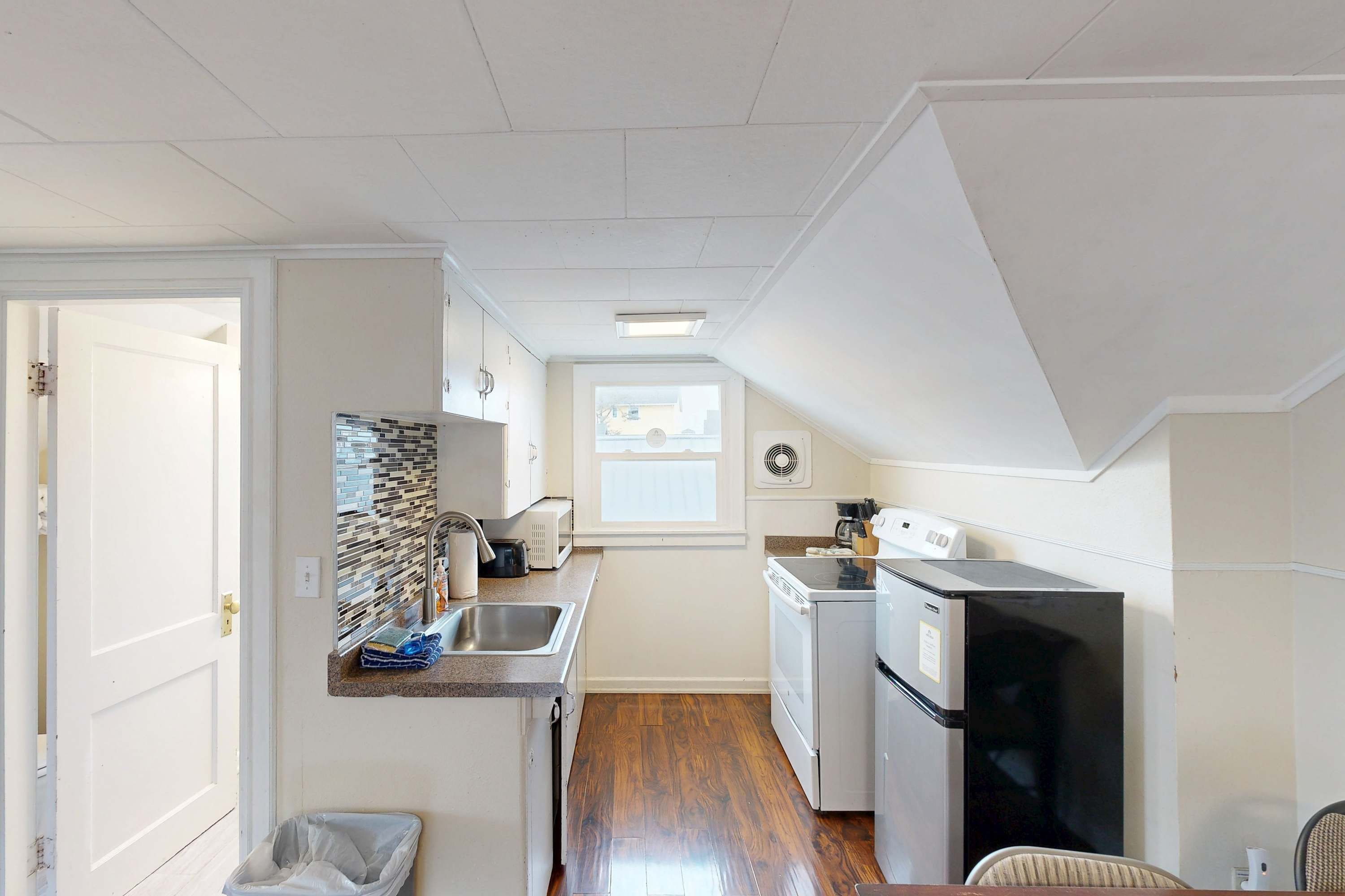 A compact kitchen with a sink, stove, and refrigerator.