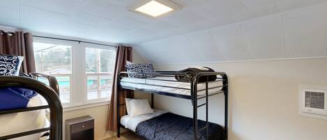 Quarto com beliche, janela, aquecedor e um pequeno armário.