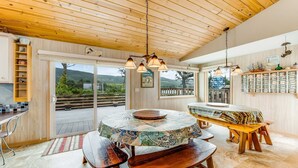 Ein Holzinterieur mit einem runden Tisch, Bänken und Blick ins Freie.