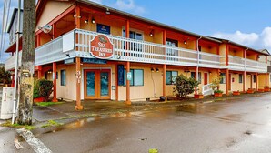 A motel with a two-story structure, a balcony on the ground floor, and a sign reading "Sea Treasures Inn." - Dog Friendly Room Located Near the Beach and Downtown (Rockaway Beach)