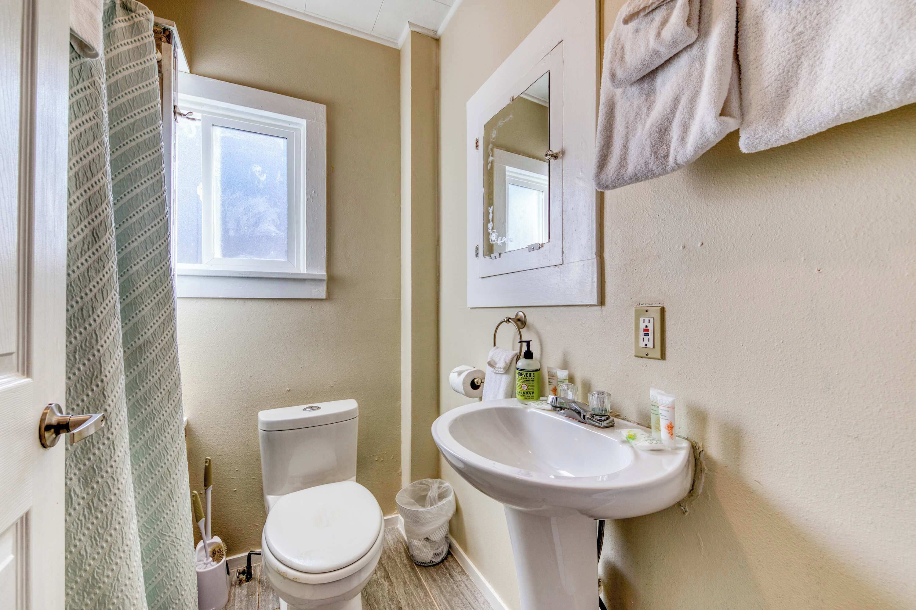 Une salle de bain avec des toilettes, un lavabo et une fenêtre.