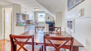 A spacious kitchen with a dining area, white cabinetry, and a large window. - Dog Friendly Triplex 3 private apartments Easy Walk to the Beach and Town (Rockaway Beach)