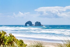 Uma praia com duas formações rochosas no oceano.